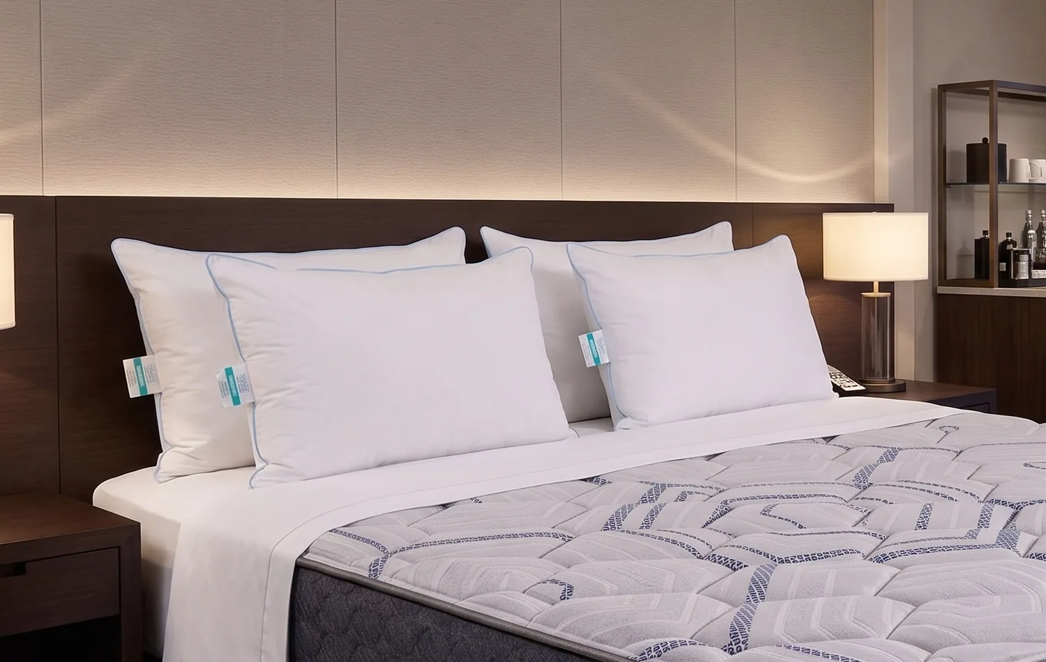Cuatro almohadas Unikonfort sobre una cama de hotel con sábanas blancas